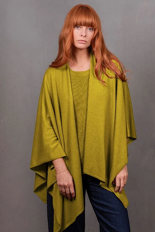Woman wearing the Citrine colour variant of the Wrap Topper made from Merino wool and cashmere from Bridge & Lord