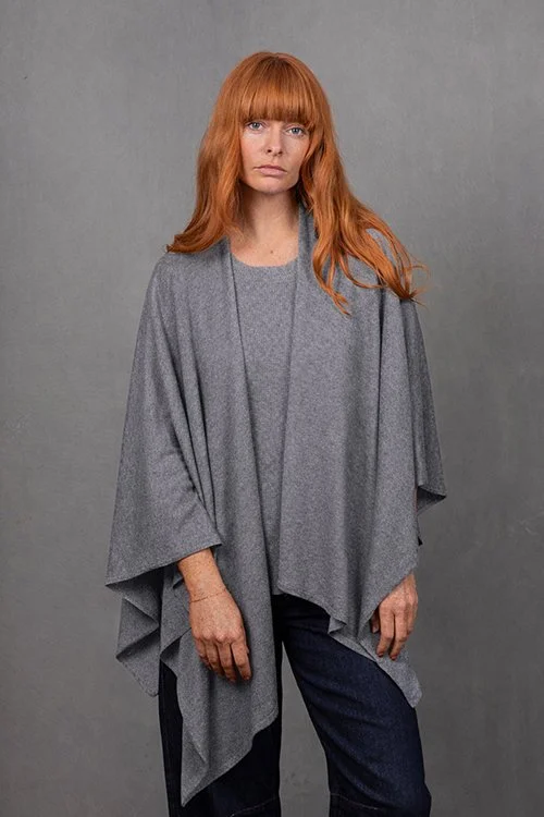 Woman wearing the Mid Grey beige colour variant of the Wrap Topper made from Merino wool and cashmere from Bridge & Lord