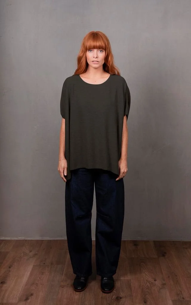 Woman wearing the Seed Stitch Poncho from Bridge and Lord in the olive green colour variant