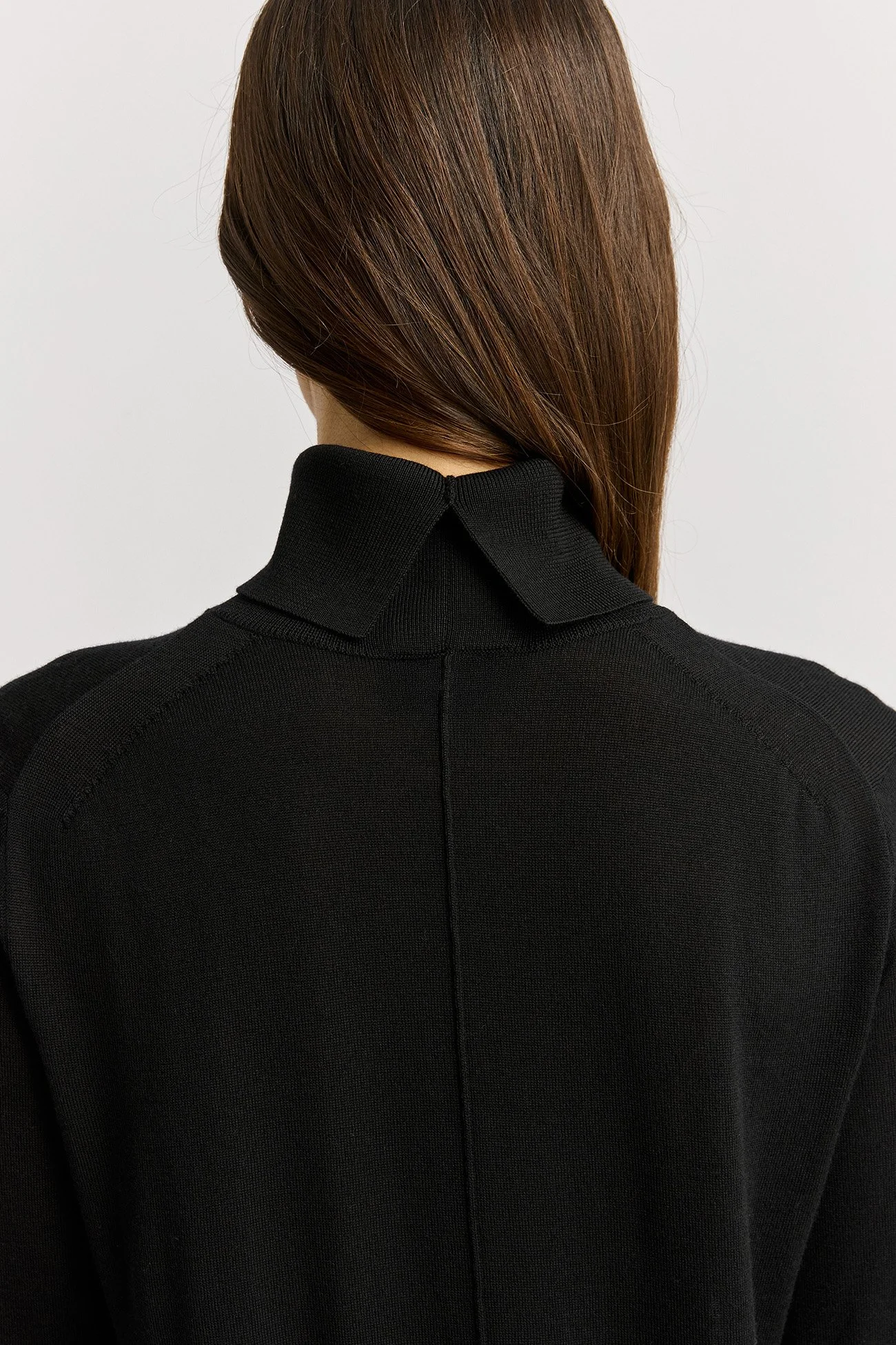 back view neck feature of a woman wearing the black colour variant of the Toorallie Extra Fine Turtle Neck Jumper