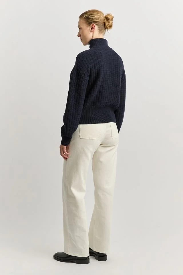 Woman wearing the Toorallie Grid Knit Zip Jacket, navy colour variant, showing the back view..