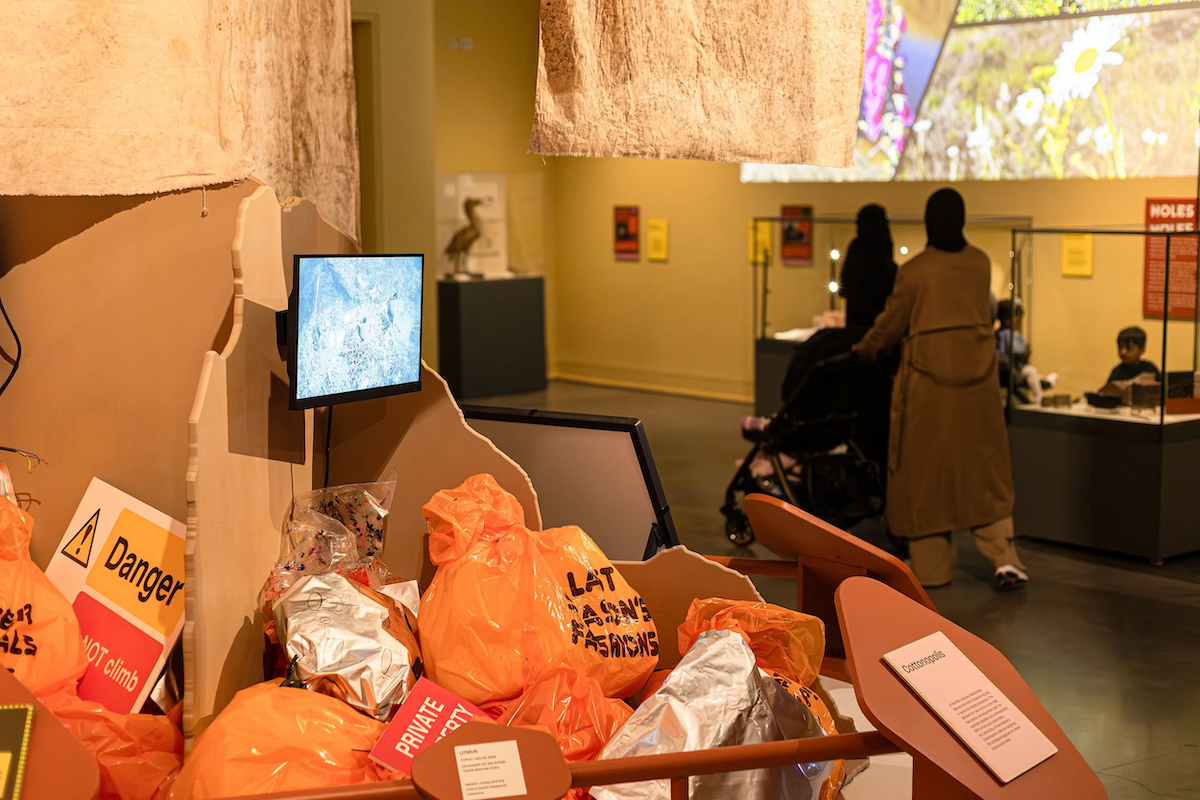 A waste dump in a museum with passersby