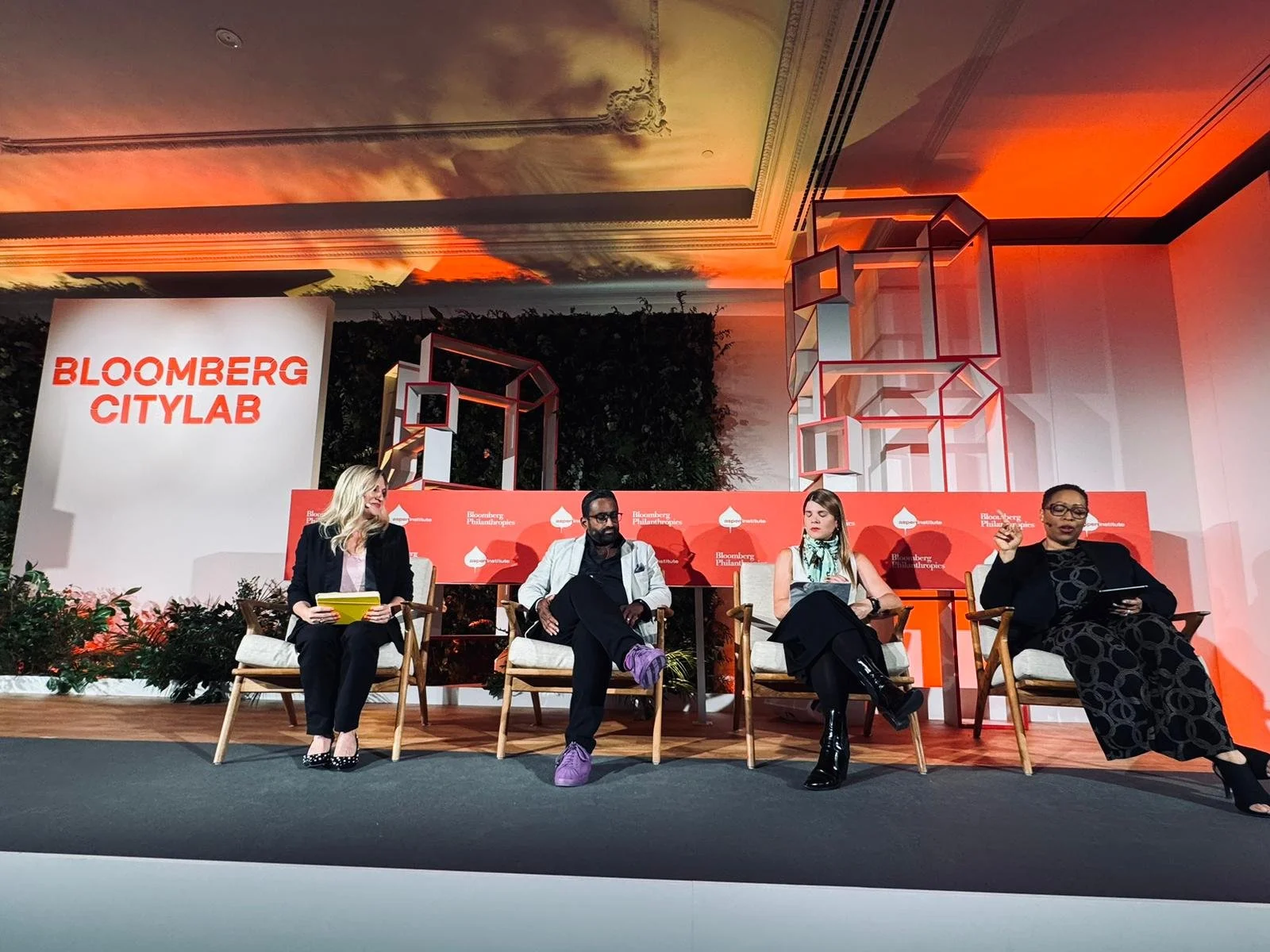4 people sit on a stage in front of a sign that reads 'Bloomberg Citylab'