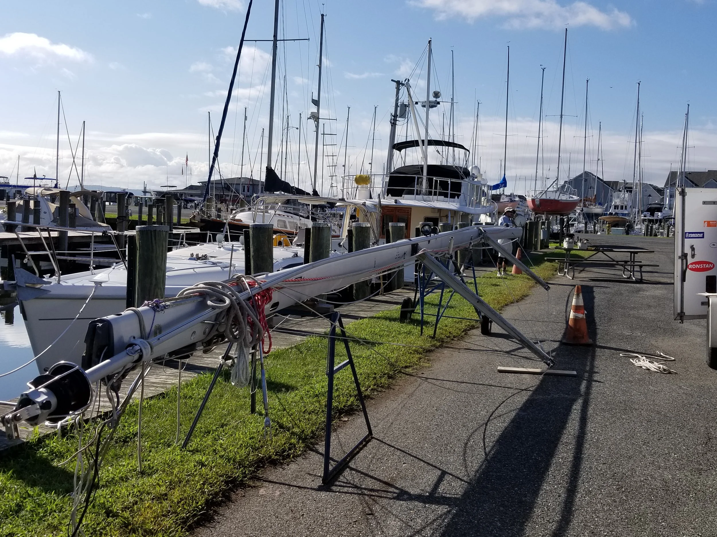 The Selden in-mast furler on this Hunter 380 suffered damage from over-tensioning. In a Seldén system, there is a turnbuckle-like screw for tensioning the extrusion. According to Seldén, the tension should be set roughly as tight as you can make it by holding the extrusion with your hand. Tighter is not recommended. To manipulate the “turnbuckle”, an aluminum sleeve (locking collar) is slid up, and the extrusion is held by hand, allowing the turnbuckle to turn while the extrusion remains stationary. The turnbuckle is turned by putting a winch handle in the socket on the back of the mast. This is the same gear that operates the furling system. With the locking collar disengaged, turning one way makes the extrusion loose. Turning the other makes it tight. Tighter also means the extrusion is getting shorter. Once the extrusion is manipulated to satisfaction, the locking collar is aligned with the turnbuckle, slid down over it and locked into place with a screw. If the locking collar is raised to manipulate the turnbuckle but then not seated properly afterwards, pulling on the furling line will put the sail away, but also tension the turnbuckle more than hand tight. This unit may not have broken at the top fitting right away, but the load on the system was set for the weakest part to fail.