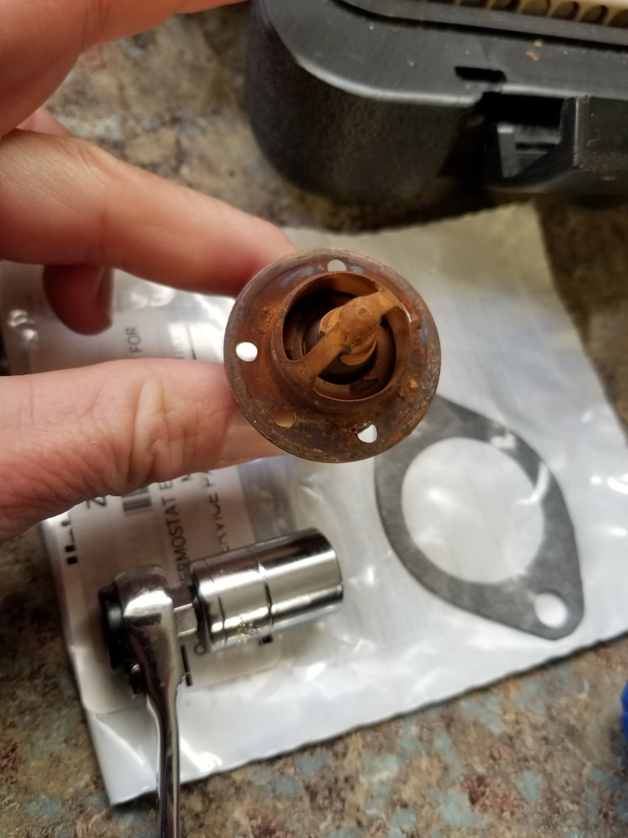 Additional holes now drilled in the thermostat is 3, plus the two that come already in it, for a total of 5. Dobbs adds holes to increase water flow through the system - the engine still comes up to a respectable temperature, but we pump more water (and less steam) out the back.