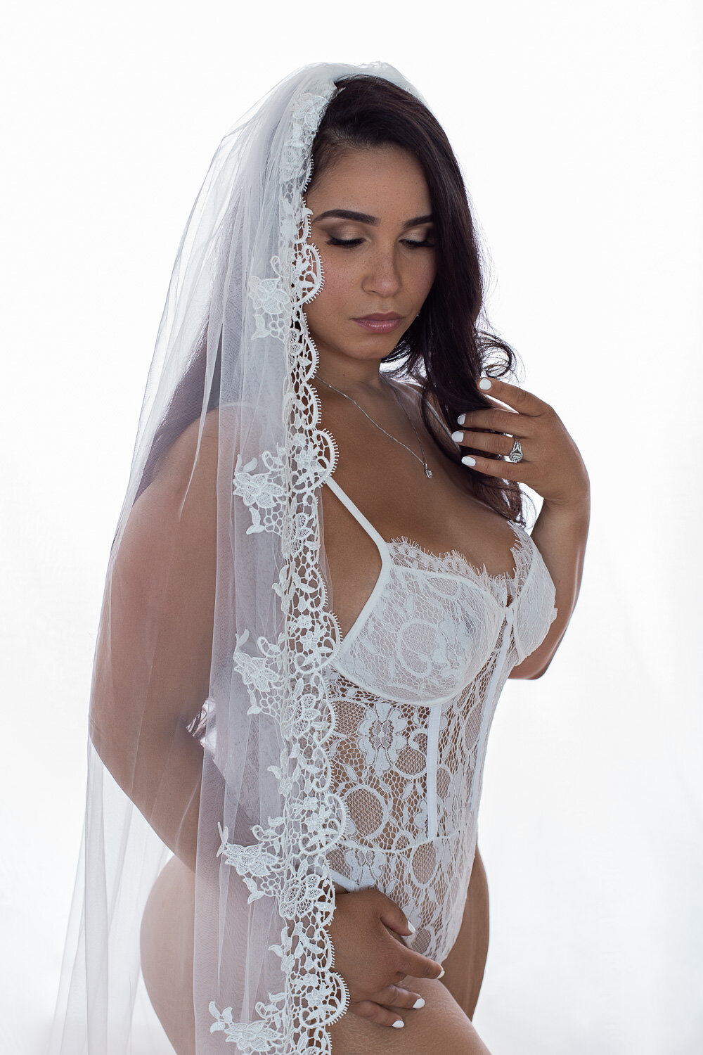 woman in white lace veil and white lace bodysuit