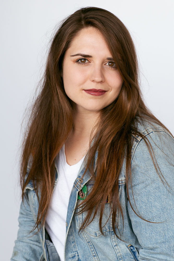 woman with long brown hair in denim jacket and white t-shirt