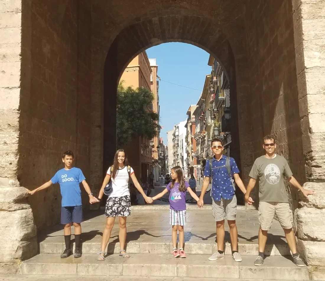 Our family holding hands at the base of Torres de Quart