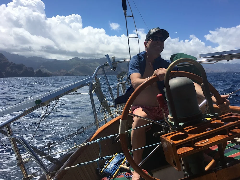 Dad steering Sedna off of Nuku Hiva at the start of our 4-day passage to the Tuamotus.