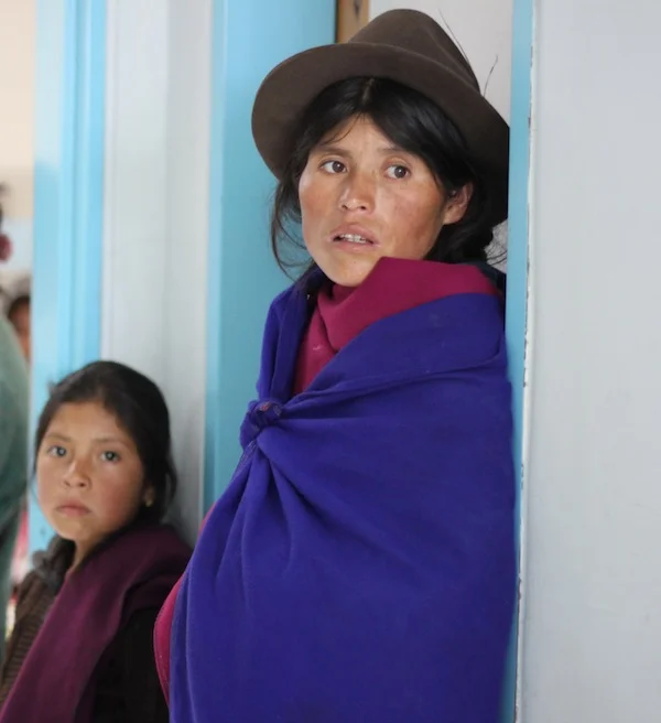 Two patients wait in the doorway to see the doctors.