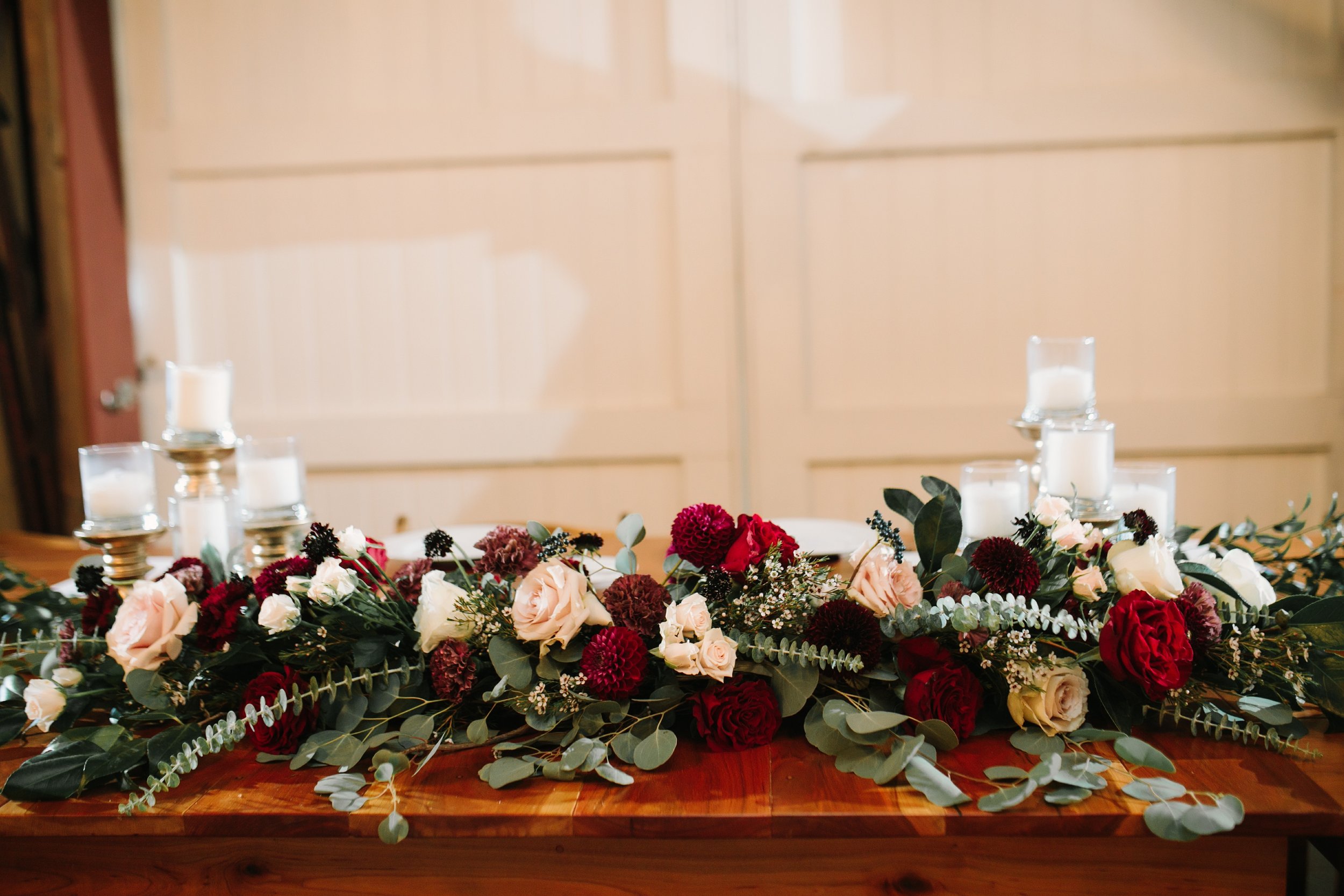 Head table flowers by red poppy floral design