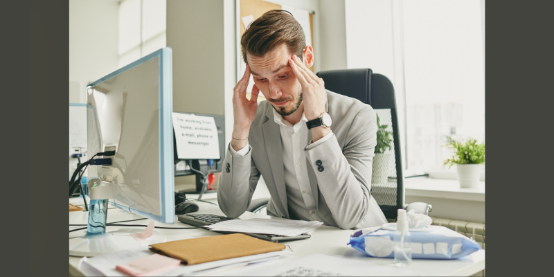 man at desk looking stressed