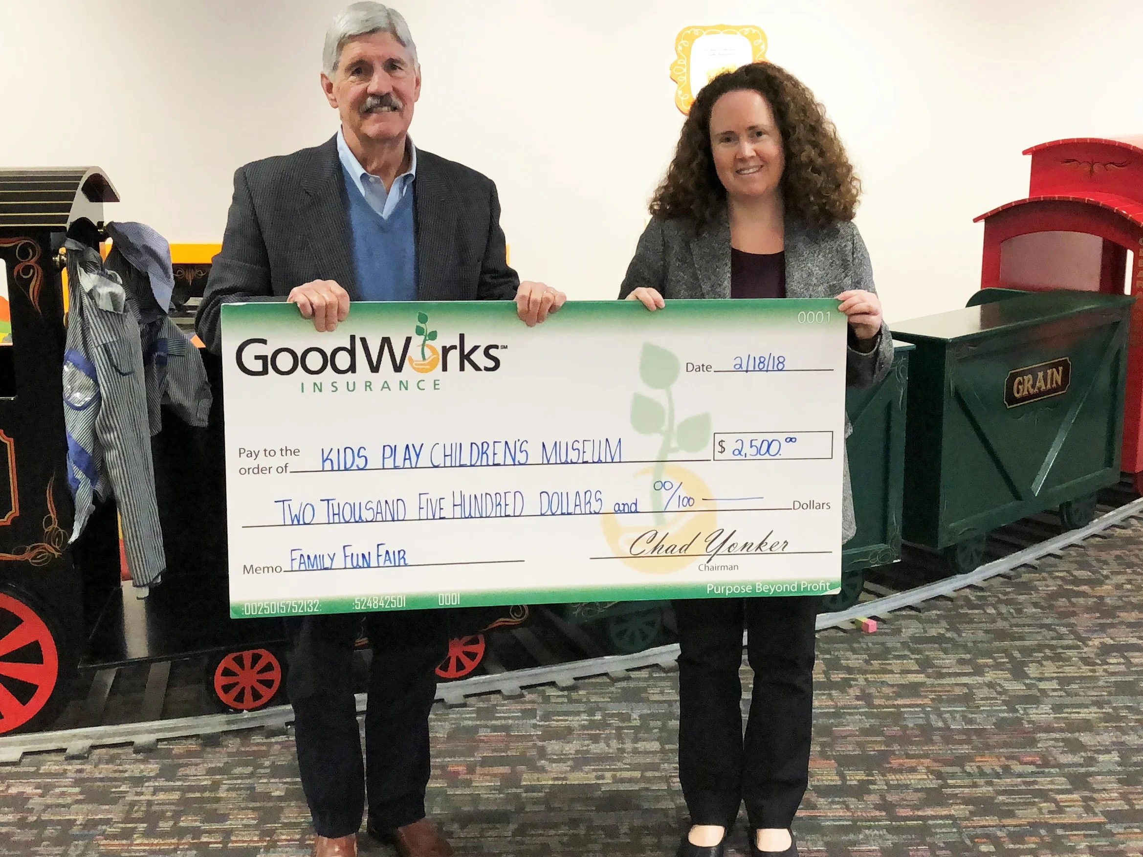 Edward F. Ryan, senior vice president with GoodWorks Insurance, presents check to Eileen Marriott, KidsPlay Children’s Museum director.