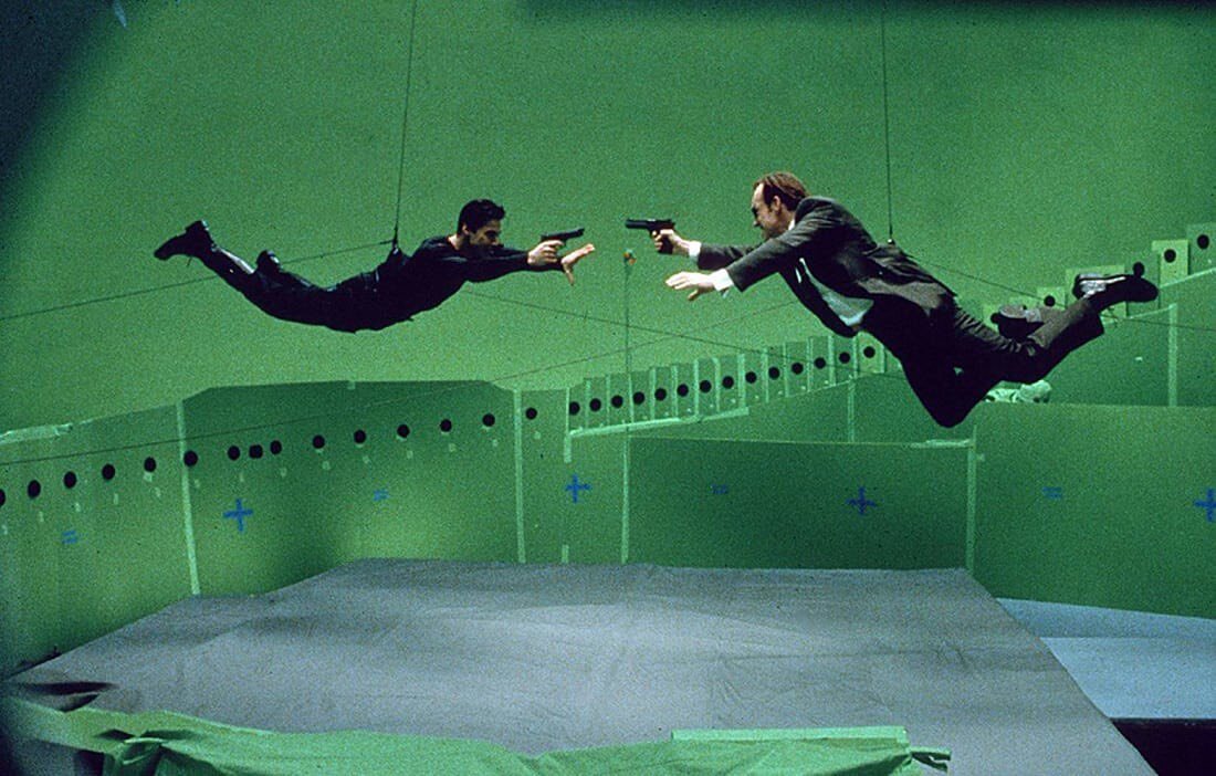 Keanu Reeves and Hugo Weaving filming The Matrix (1999) with its revolutionary Bullet Time technology, an effect achieved photographically by a set of still cameras fired sequentially surrounding the subject