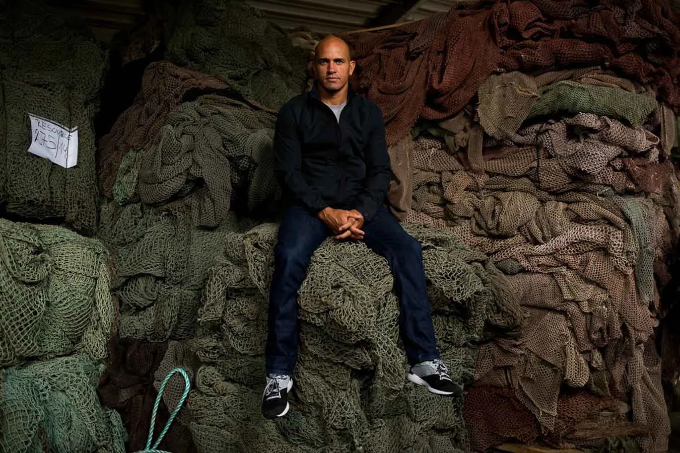 Kelly Slater sits on top of recycled fishing nets on a factory visit in Slovenia. Photo: Todd Glaser