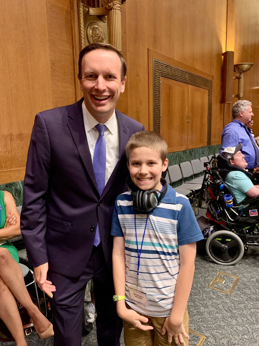  A young boy poses with a U.S. Senator in a meeting room in the Senate. 