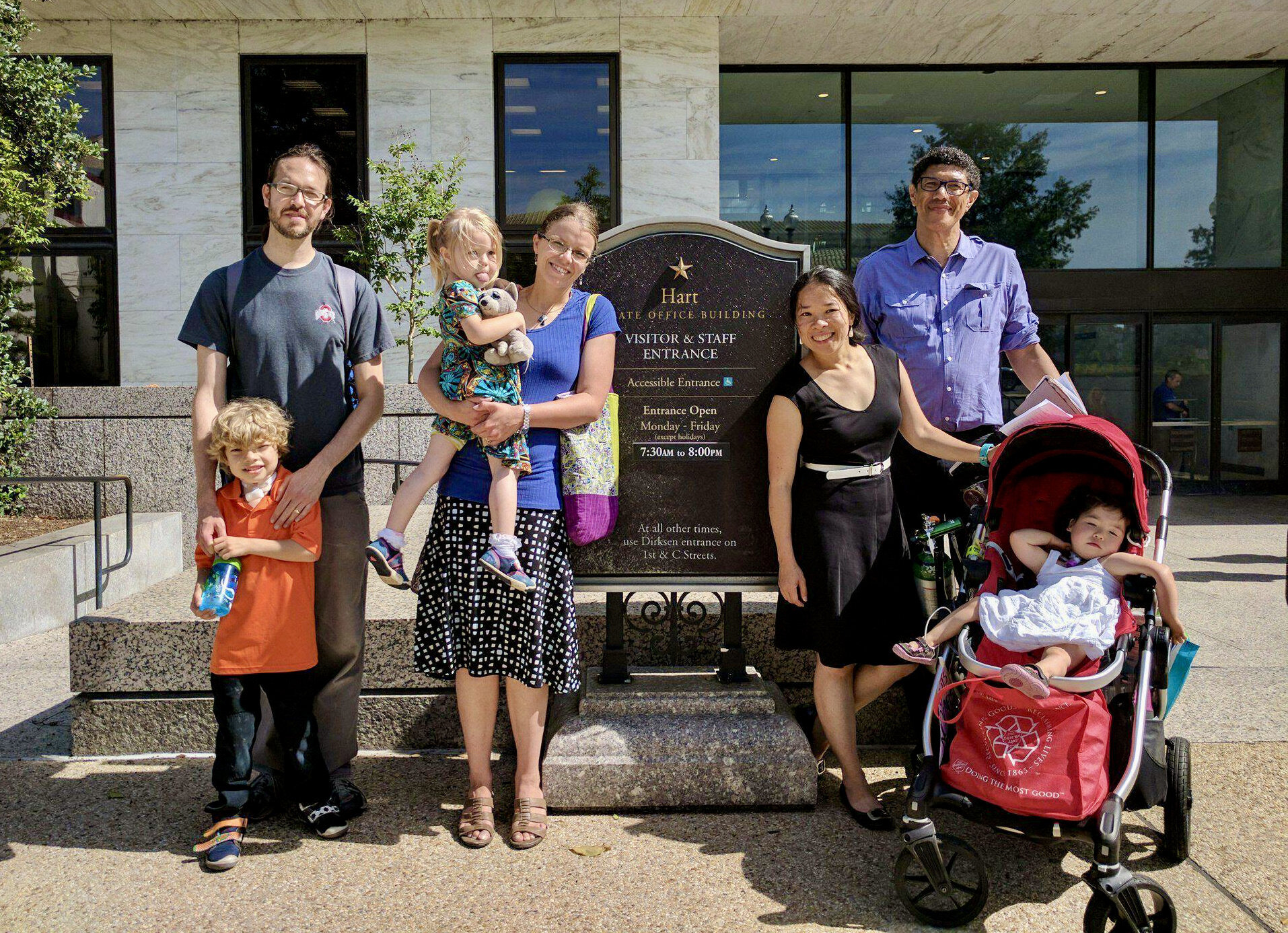  Several Little Lobbyists families pose outside the U.S. Hart Senate Office building, next to its sign. 