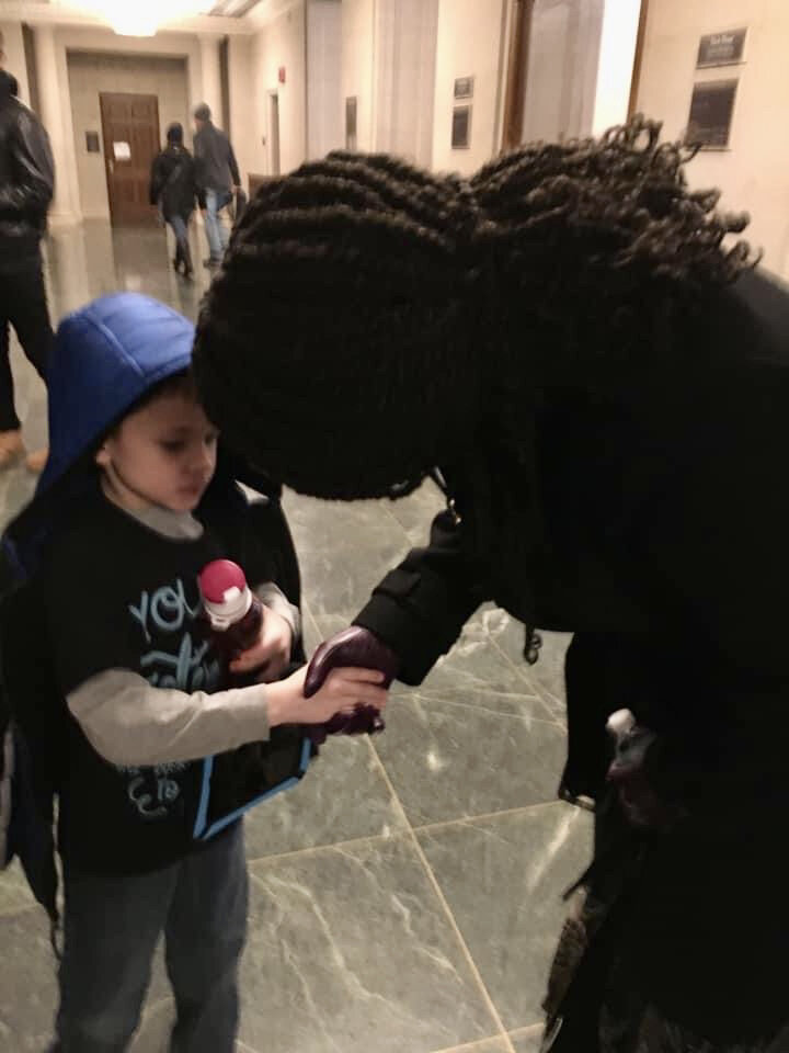  A child receives a handshake from a new member of Congress. 