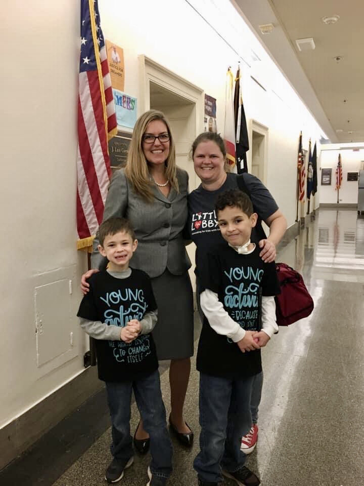  Little Lobbyists family poses with their U.S. representative in a hallway in Congress. 
