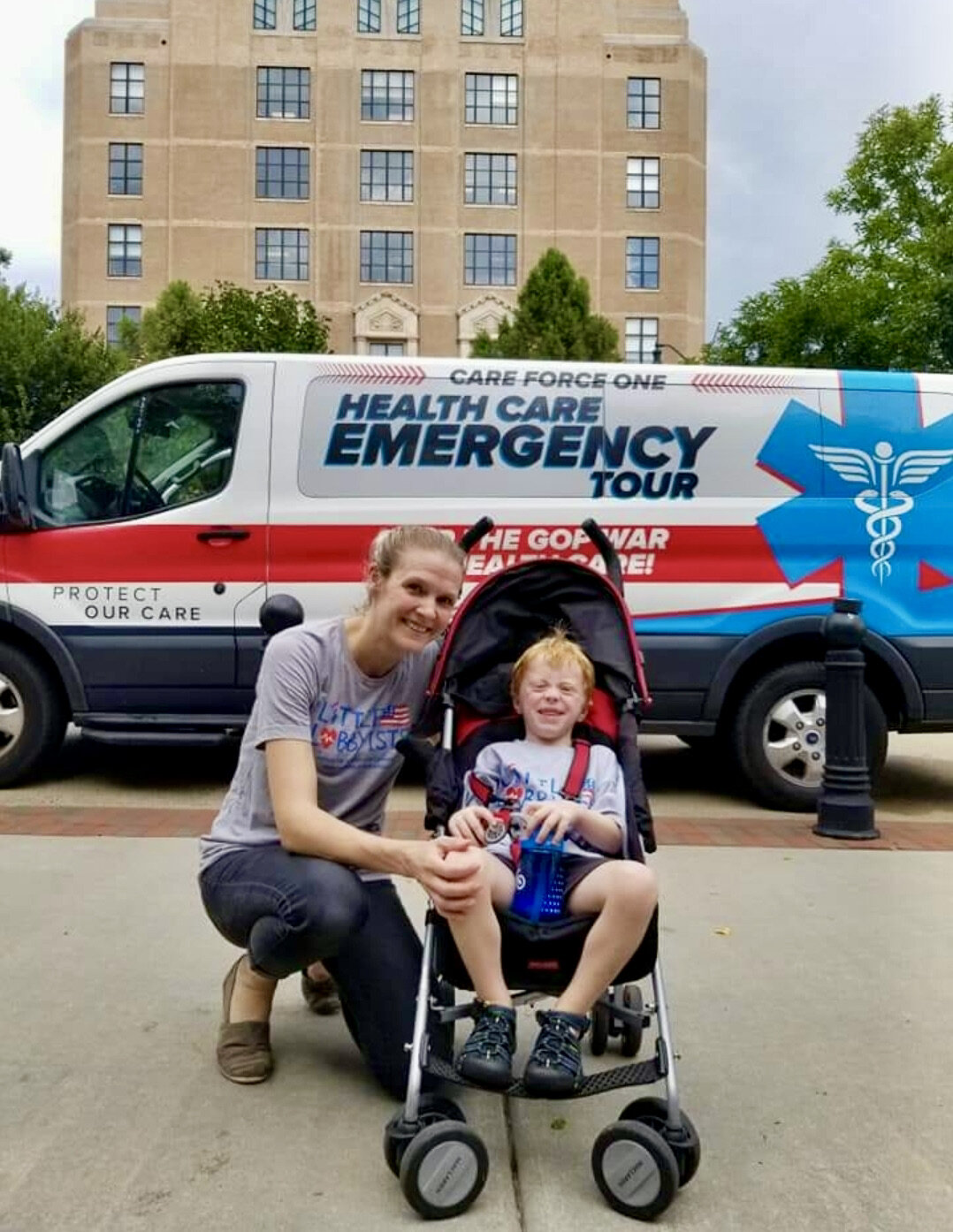  A mom poses with her child (who uses a disability stroller) in front of an ambulance during a health care public service campaign. 