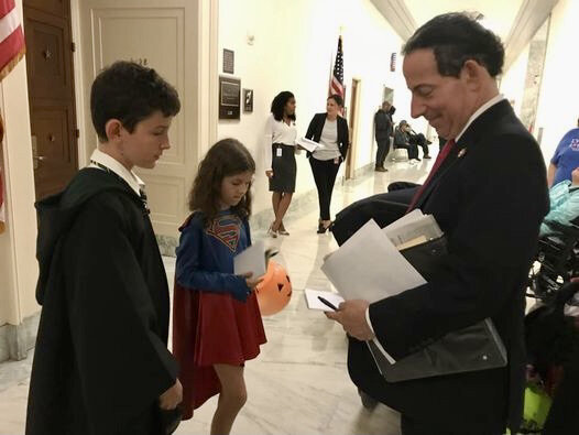  Two children dressed in Halloween costumes wait for a U.S. congressman to sign his autograph. 