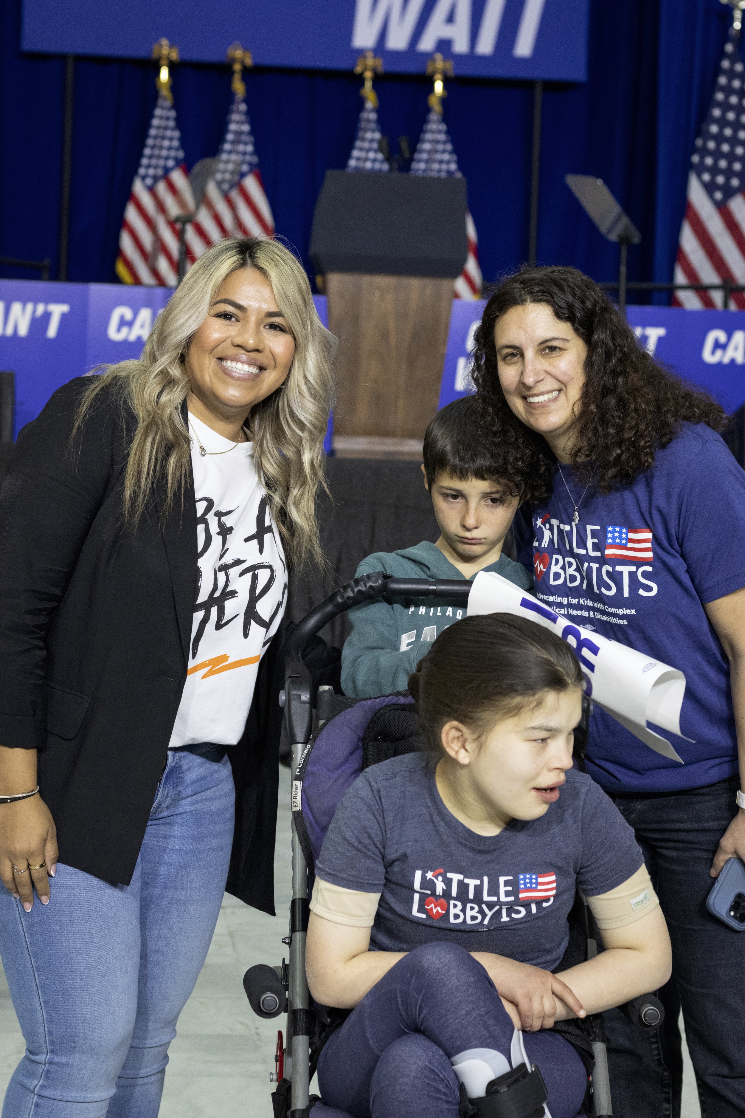  Jamie, her daughter Claire (who uses an adapted stroller) and son Ben pose in front of the stage, with Izzy, a careworker for the late Day Barkan.  