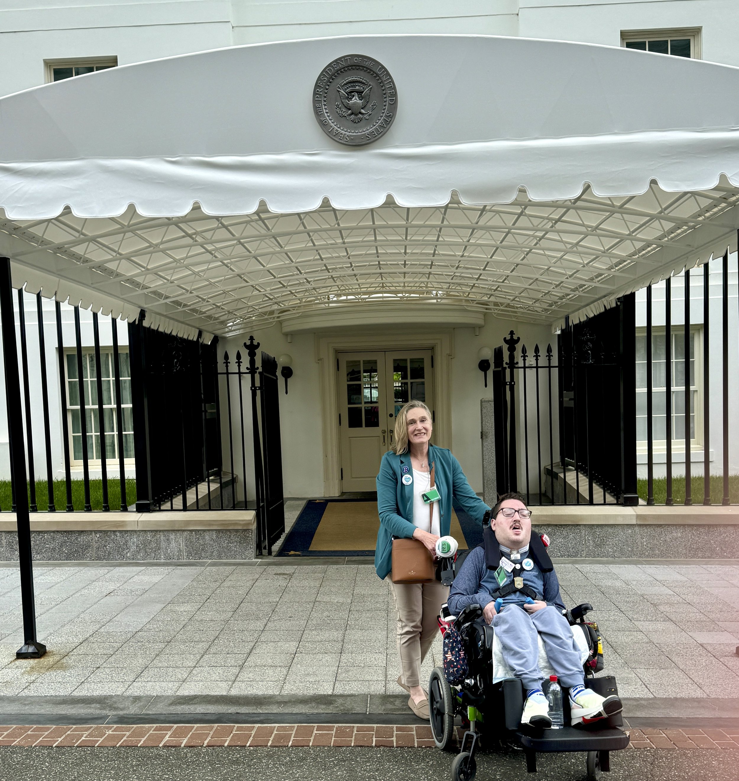  Rob and Jeneva pose outside the White House, under a white arrival canopy with the presidential seal. 