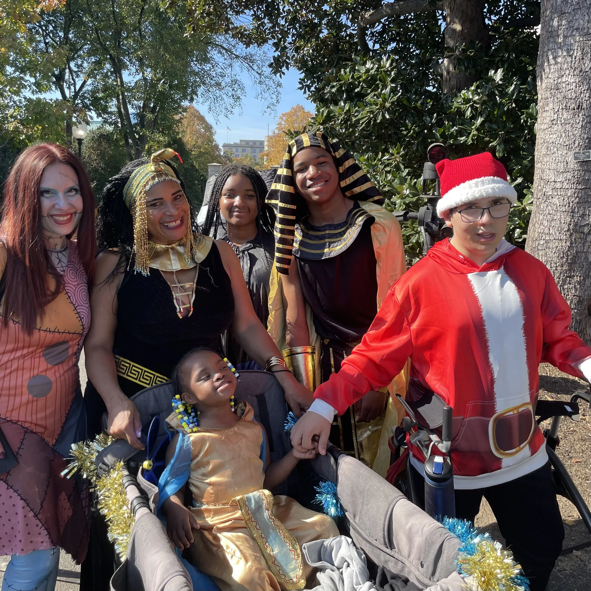 Little Lobbyists Destiny (an Egyptian princess) and Simon (Santa) hold hands and pose with their families during the White House Hallo-read celebration!