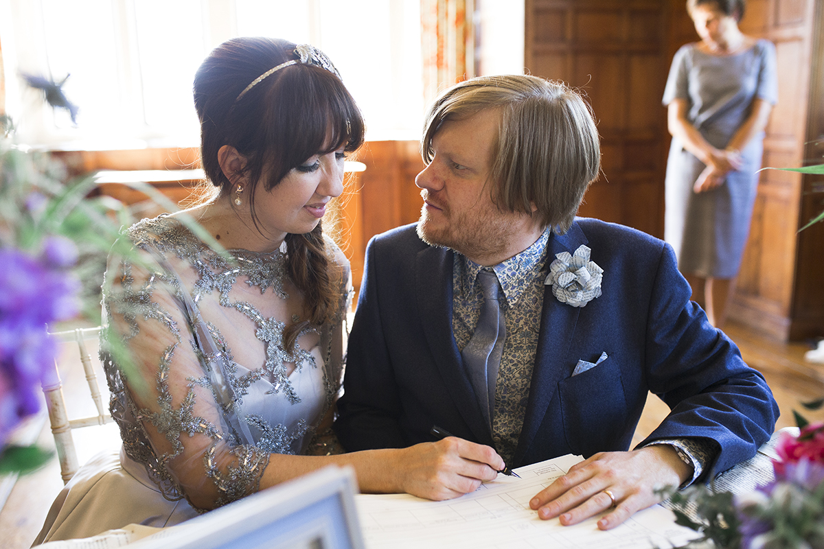 Bride and groom signing register Sophie Lake Photography