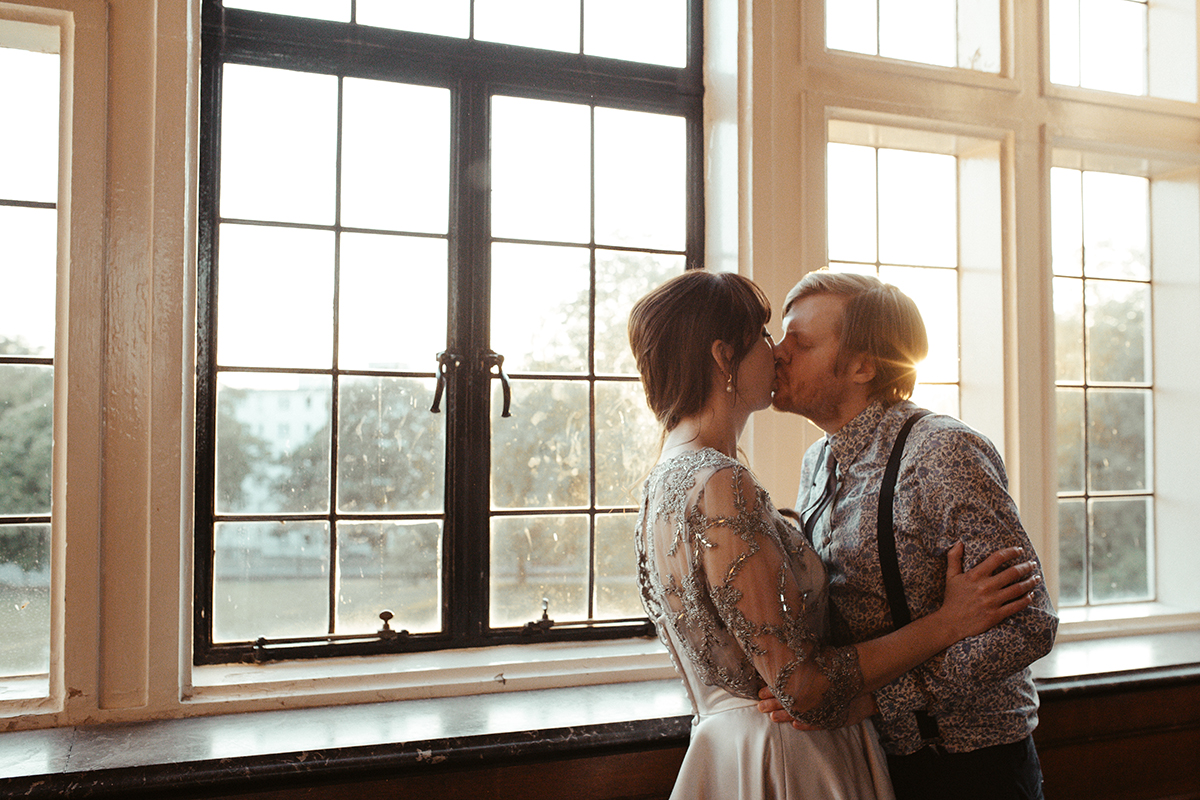 Bride and Groom kissing by window Sophie Lake Photography