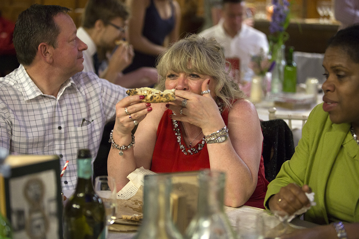 Wedding guest eating pizza Sophie Lake Photography