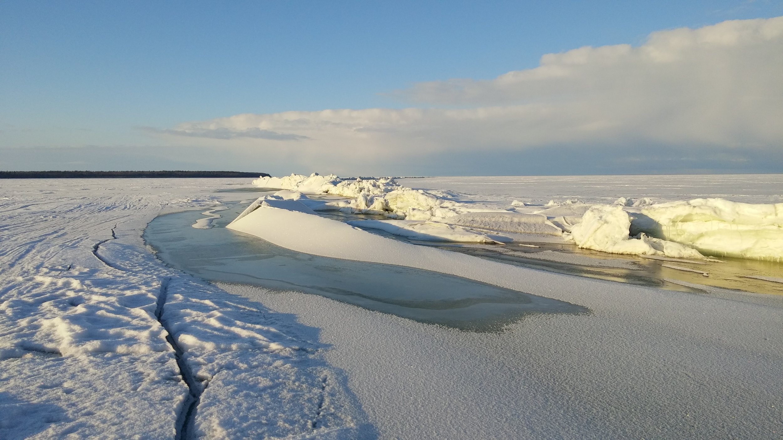 Trough deformation adjacent to ridge and uplift as ice expands. Water-filled troughs freeze with thin ice at night.