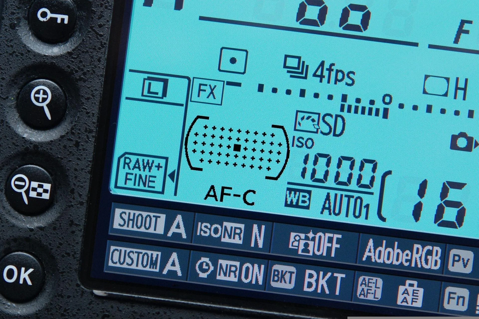 A digital camera's LCD screen displaying camera settings including ISO 1000, shutter speed 1/15, and other shooting parameters.