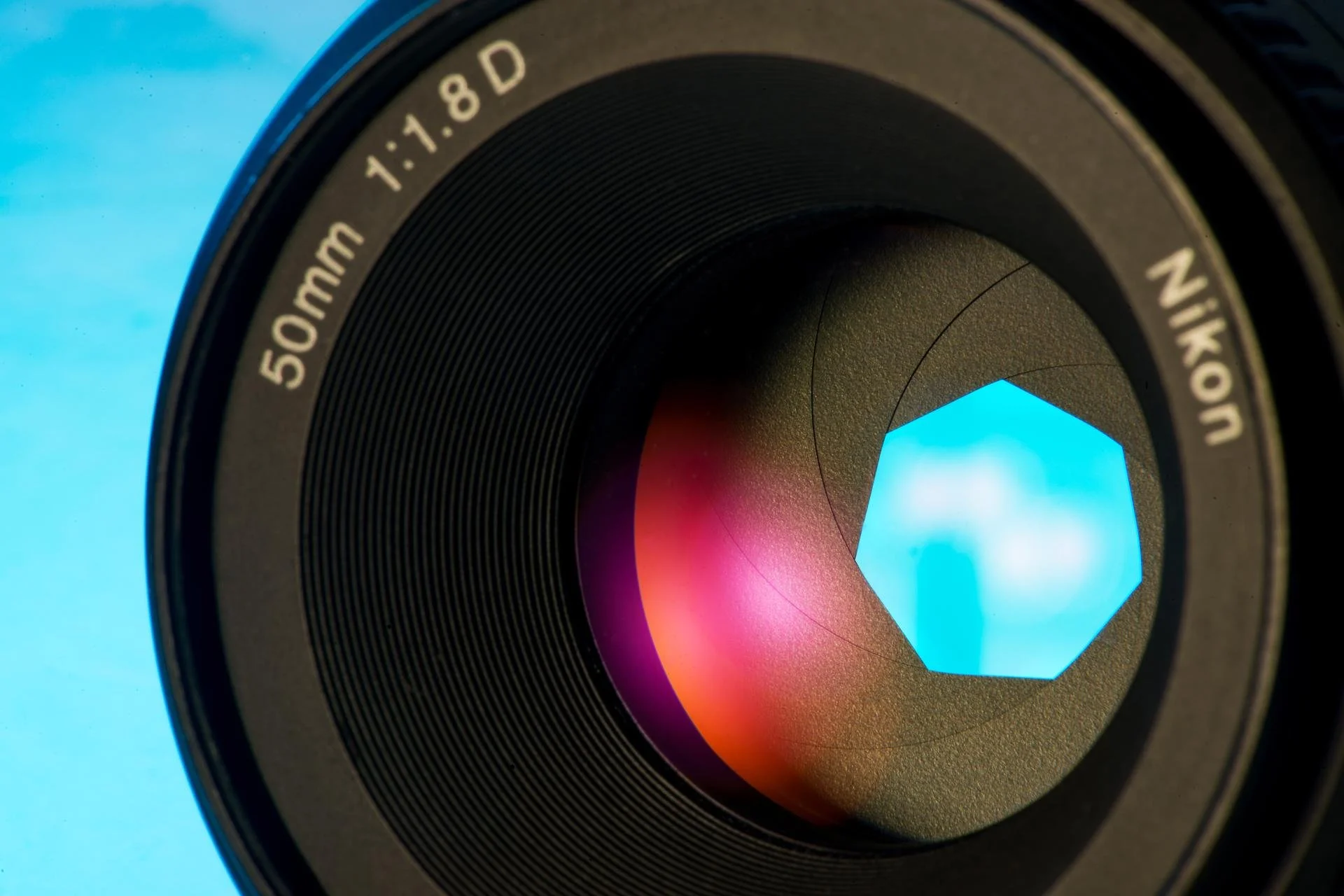 Close-up of a Nikon camera lens showing details of the lens and the aperture blades.