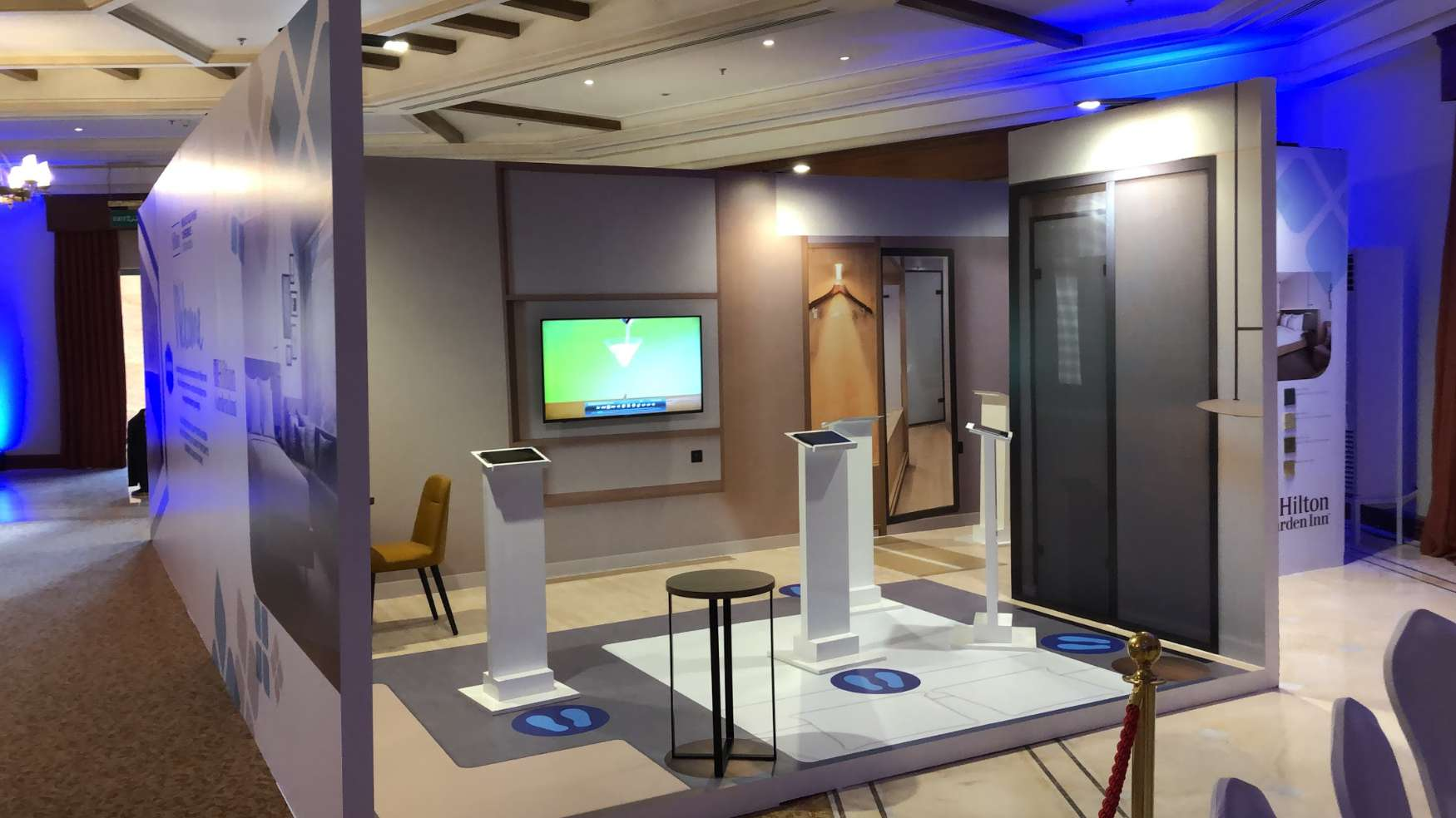 Empty event room with tablet plinths where guests viewed AR hotel rooms for Hilton