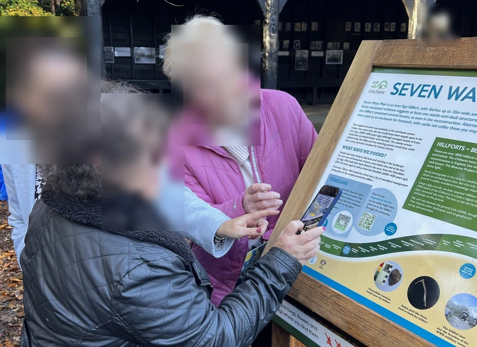 Visitors scanning the QR code on the Seven Ways Plain board to launch the AR experience
