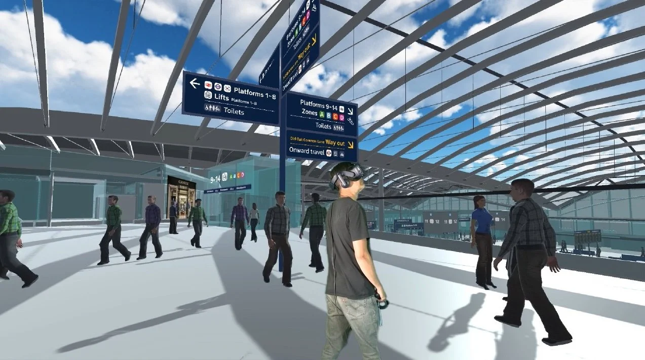 Virtual HS2 Old Oak Common concourse with wayfinding signs and a simulated crowd