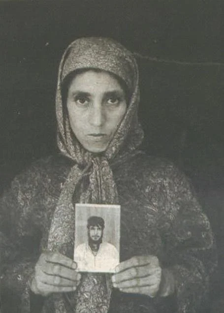 A woman holding a photograph of her relative disappeared by the Indian forces. Photo: APDP Archives