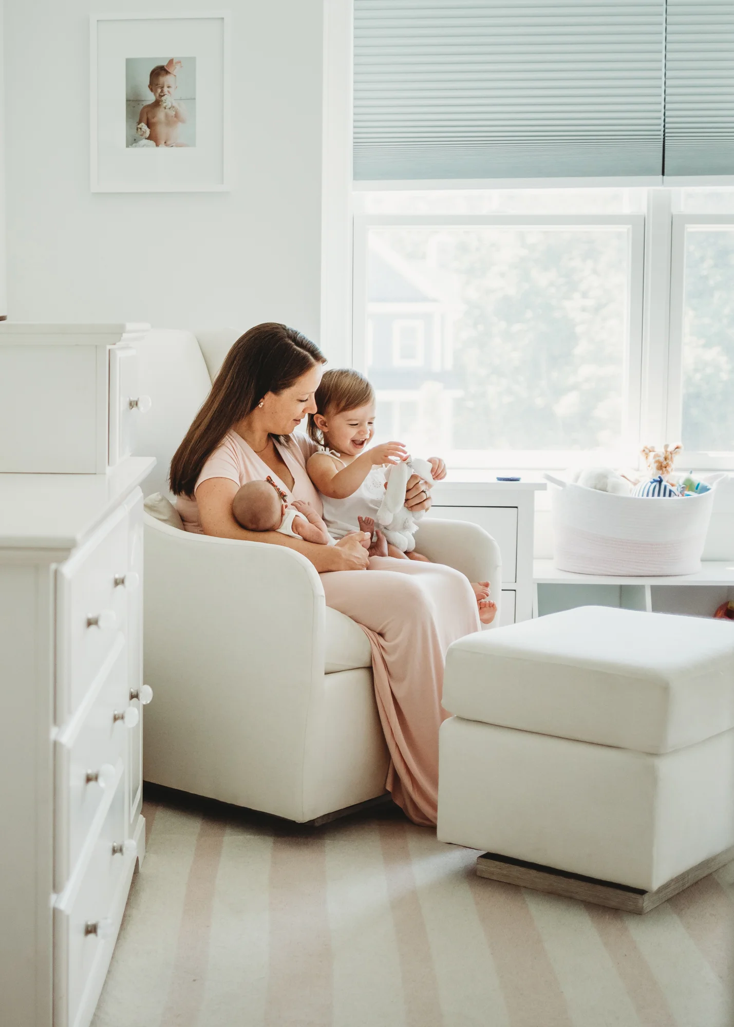 Mom with toddler daughter and newborn daughter in their nursery in Wayland, Massachusetts. Greater Boston newborn photographer. Natural light, lifestyle portraiture.
