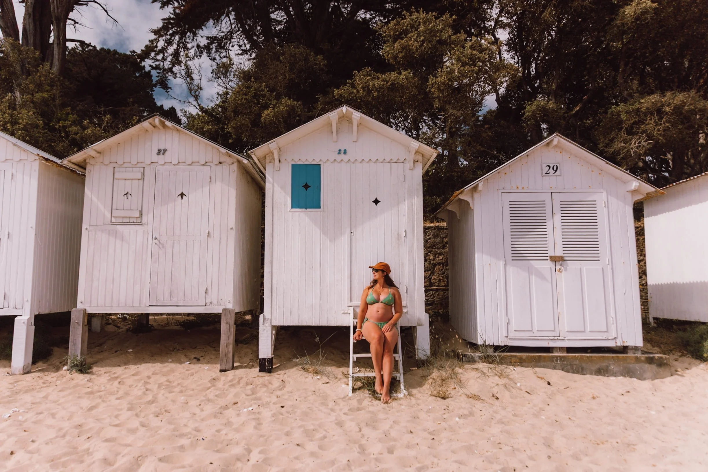 woman sitting infront of white beach huts