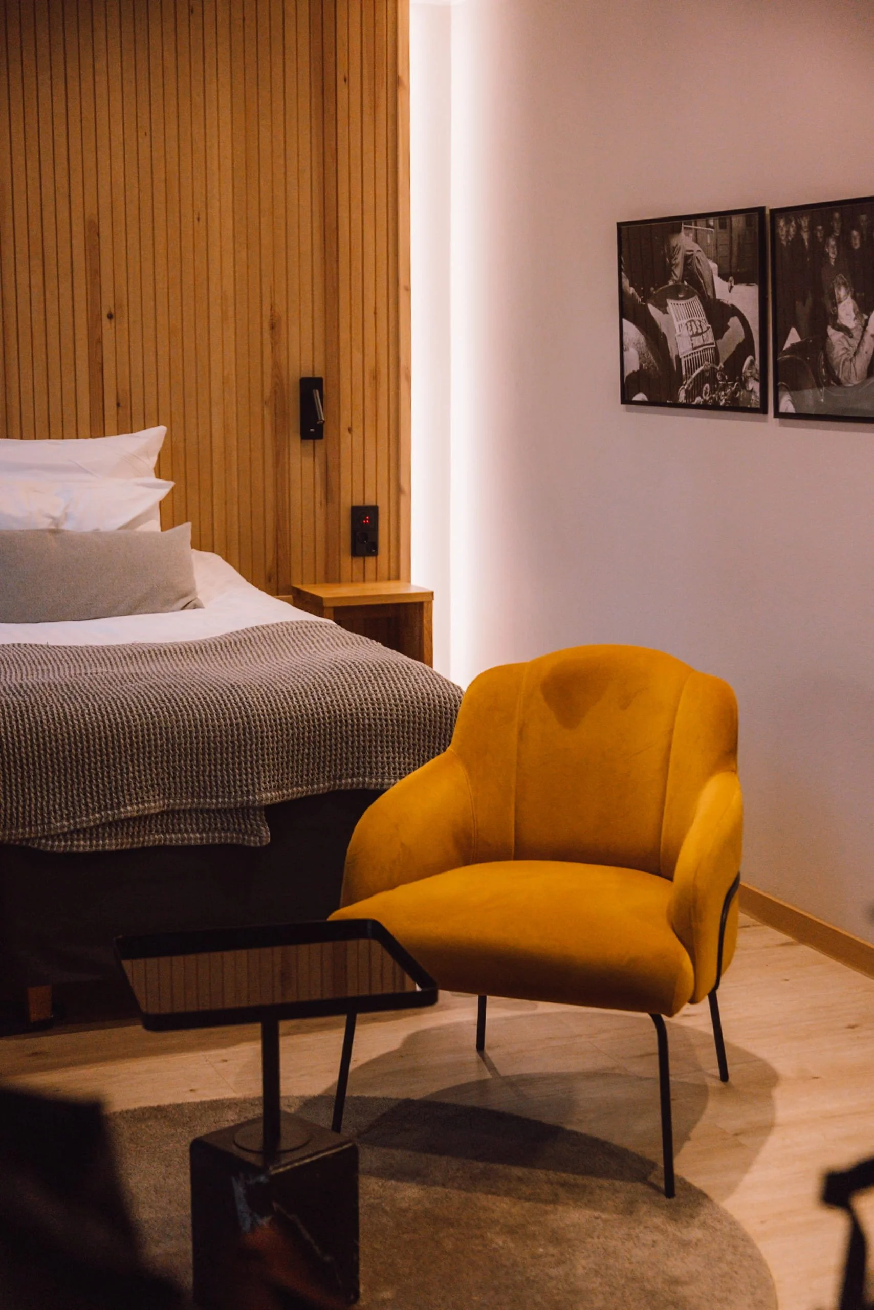Bedroom at Hotel Verso with yellow velvet chair, bed and wooden panelling