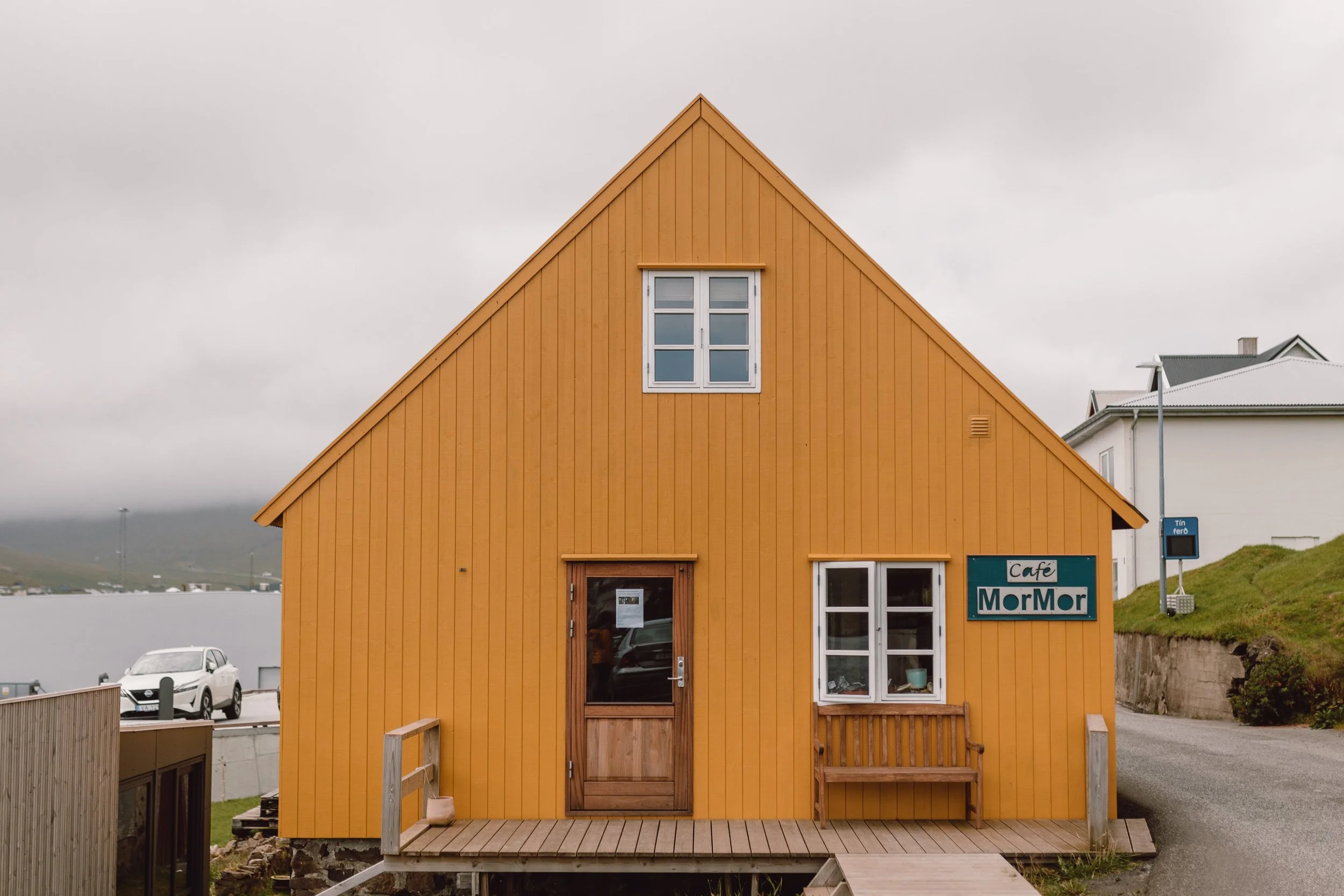 yellow traingle building with wooden cladding cafe mormor in suduroy