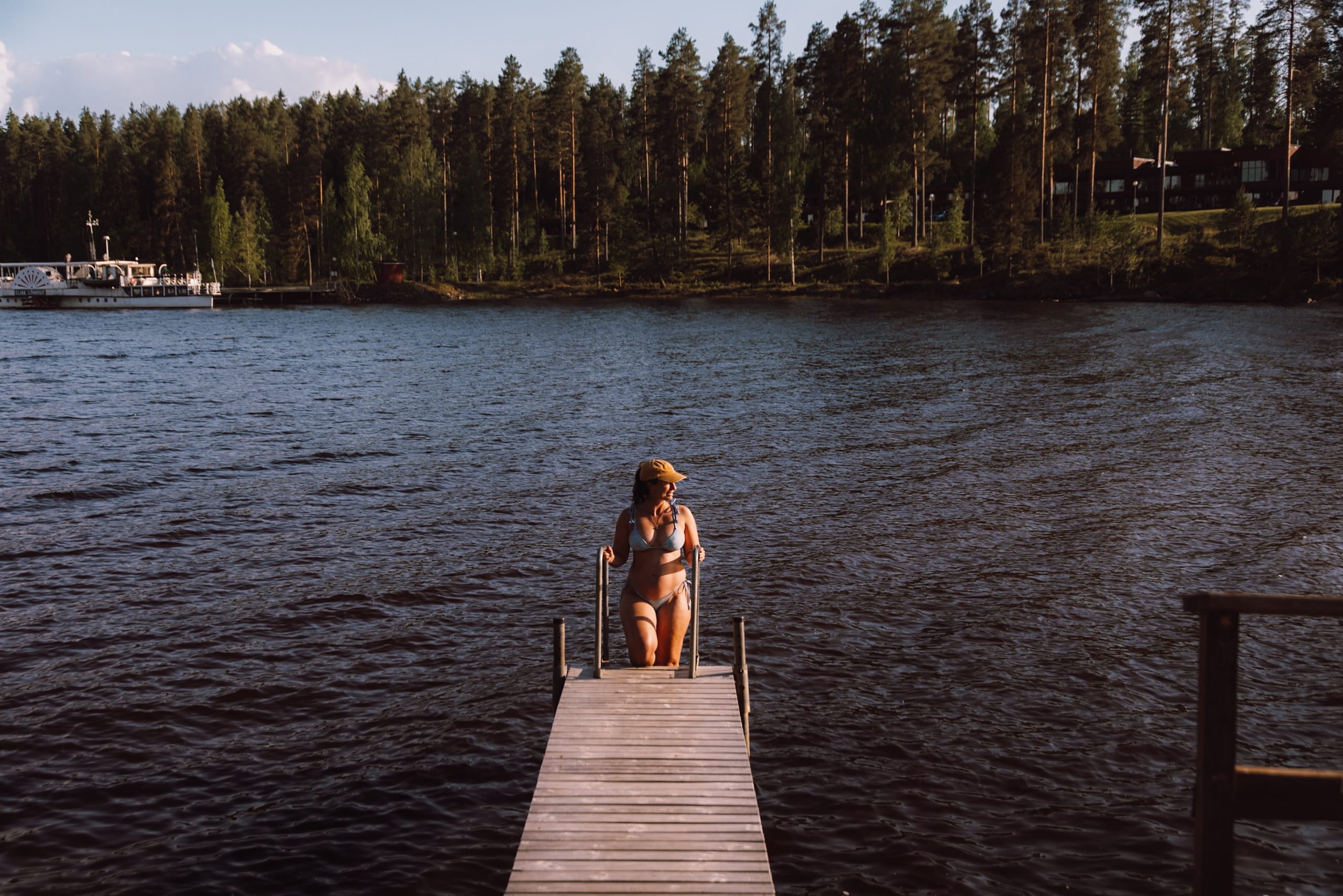 woman walking down steps to swim in lake from sauna