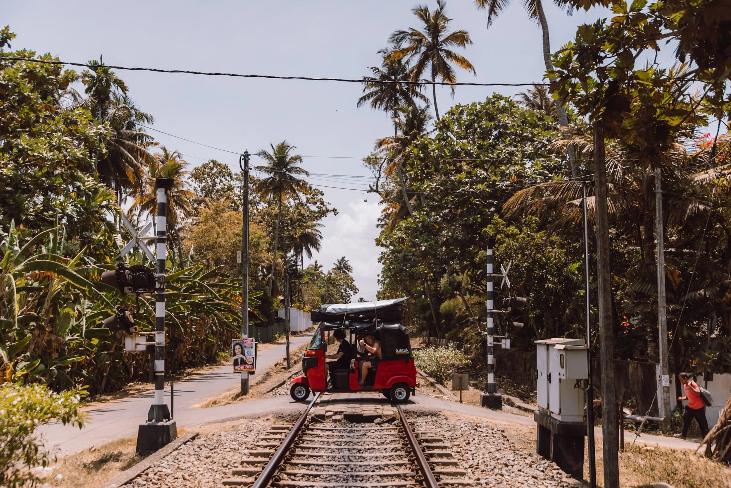 tuk tuk driving over train tracks in Sri Lanka