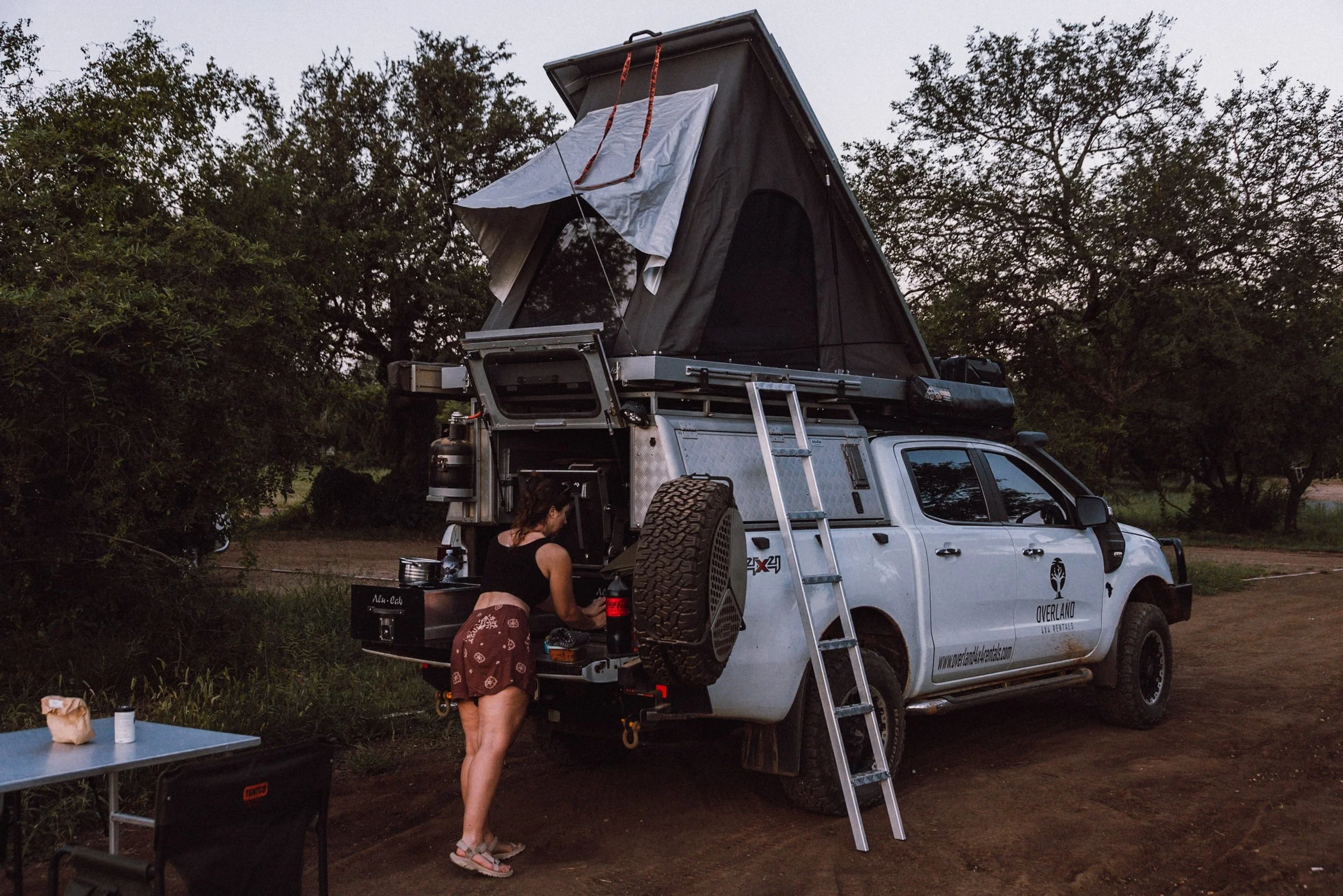 4x4 campervan in Satara main camp where woman is setting up dinner