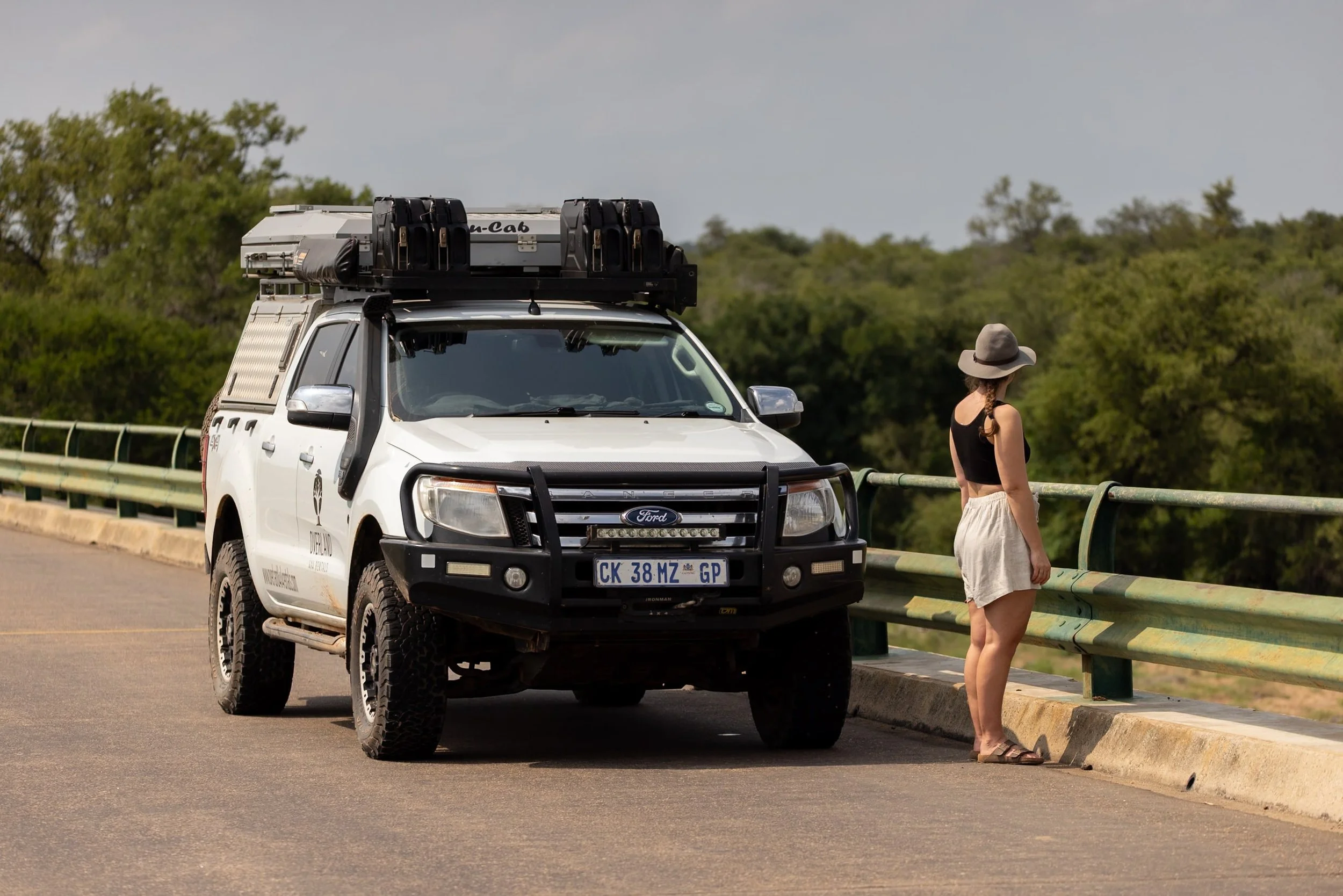 4x4 car parked on bridge with women standing next to it