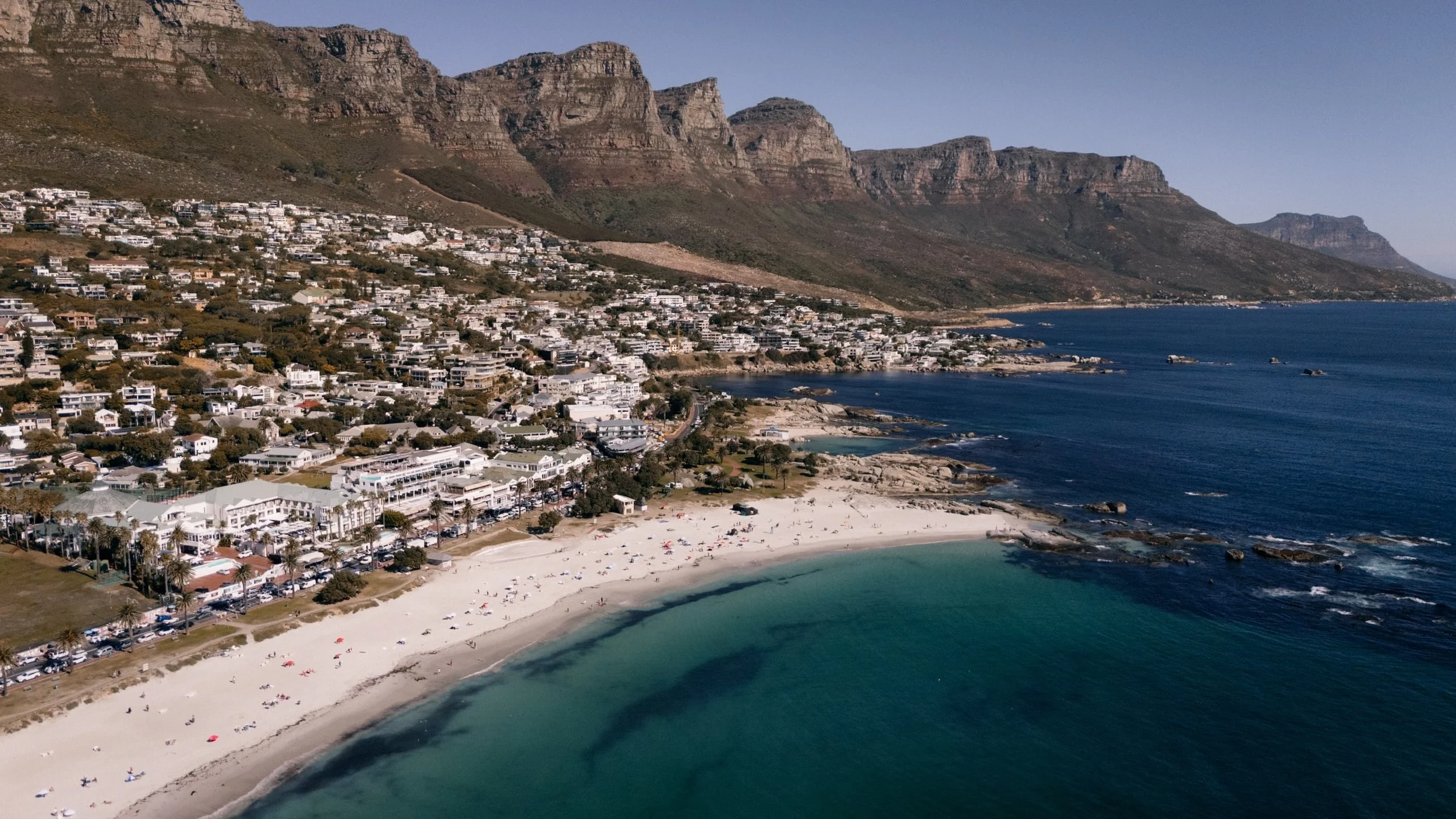 aerial image of camps bay cape town with sandy beach and clear water