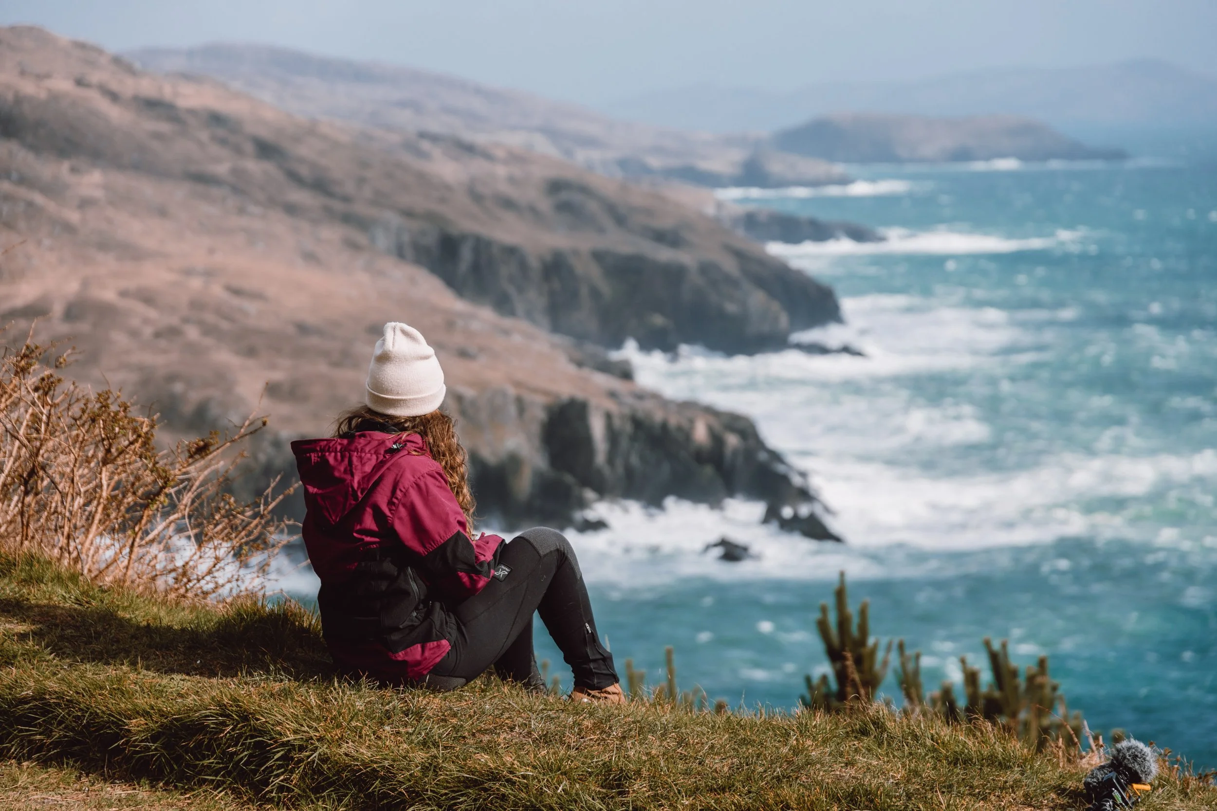 Woman sat infront of cliffs with view across Atlantic Ocean atDzogchen Beara