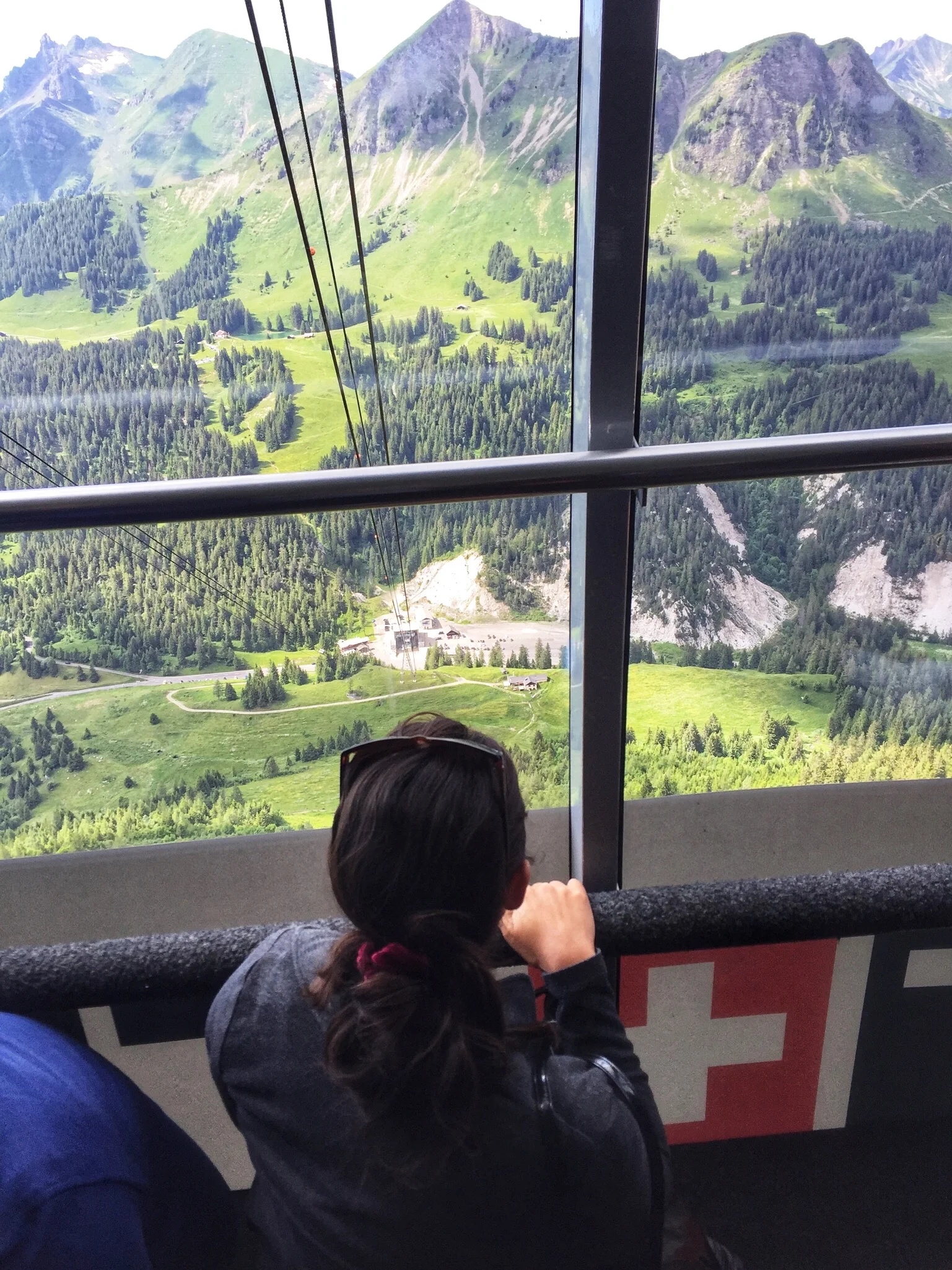 Naomi, tackling her fear of heights the entire day, bravely peeks through the window during the trip down in the Gondola. 