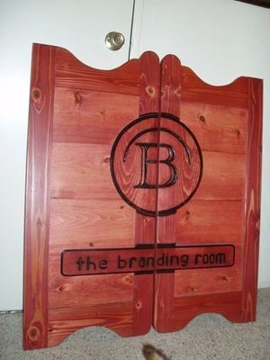 The Branding Room western saloon door with red stain and company logo